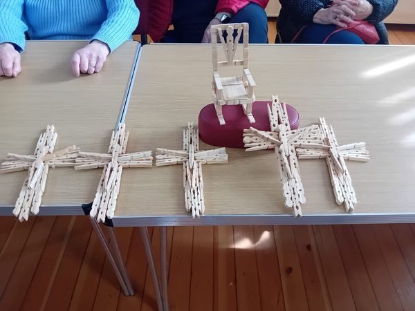 wooden crosses made out of clothes-pegs and a small chair made out of clothes-pegs